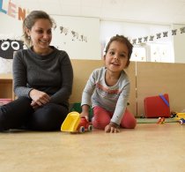 Pedagogisch medewerker met spelende peuter op een kinderdagverblijf