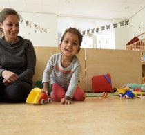 Pedagogisch medewerker met peuter op een kinderdagverblijf